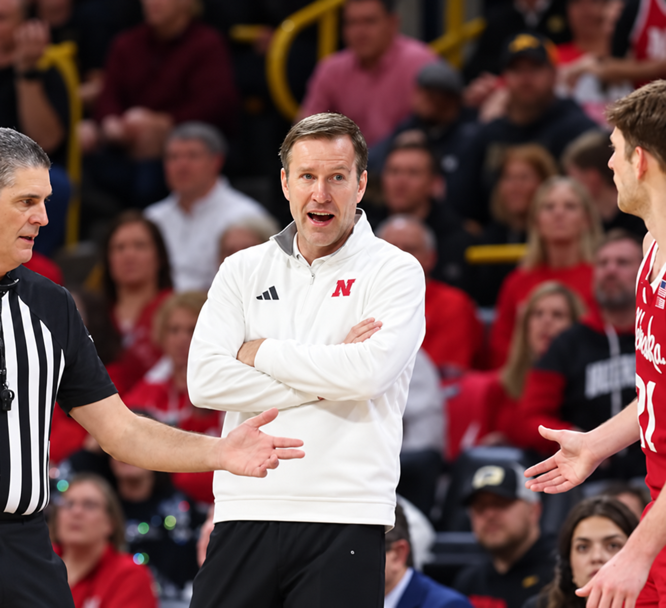 Fred Hoiberg courtside with folded arms during a Nebraska basketball game